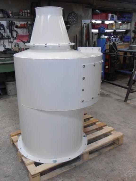 Matériel industriel blanc sur palette en bois, corps cylindrique avec dessus conique, dans un atelier.