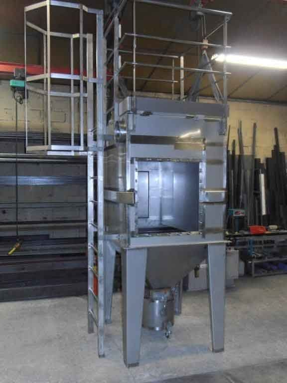 Machine industrielle en métal avec échelle, passerelle et trémie en configuration d'usine.