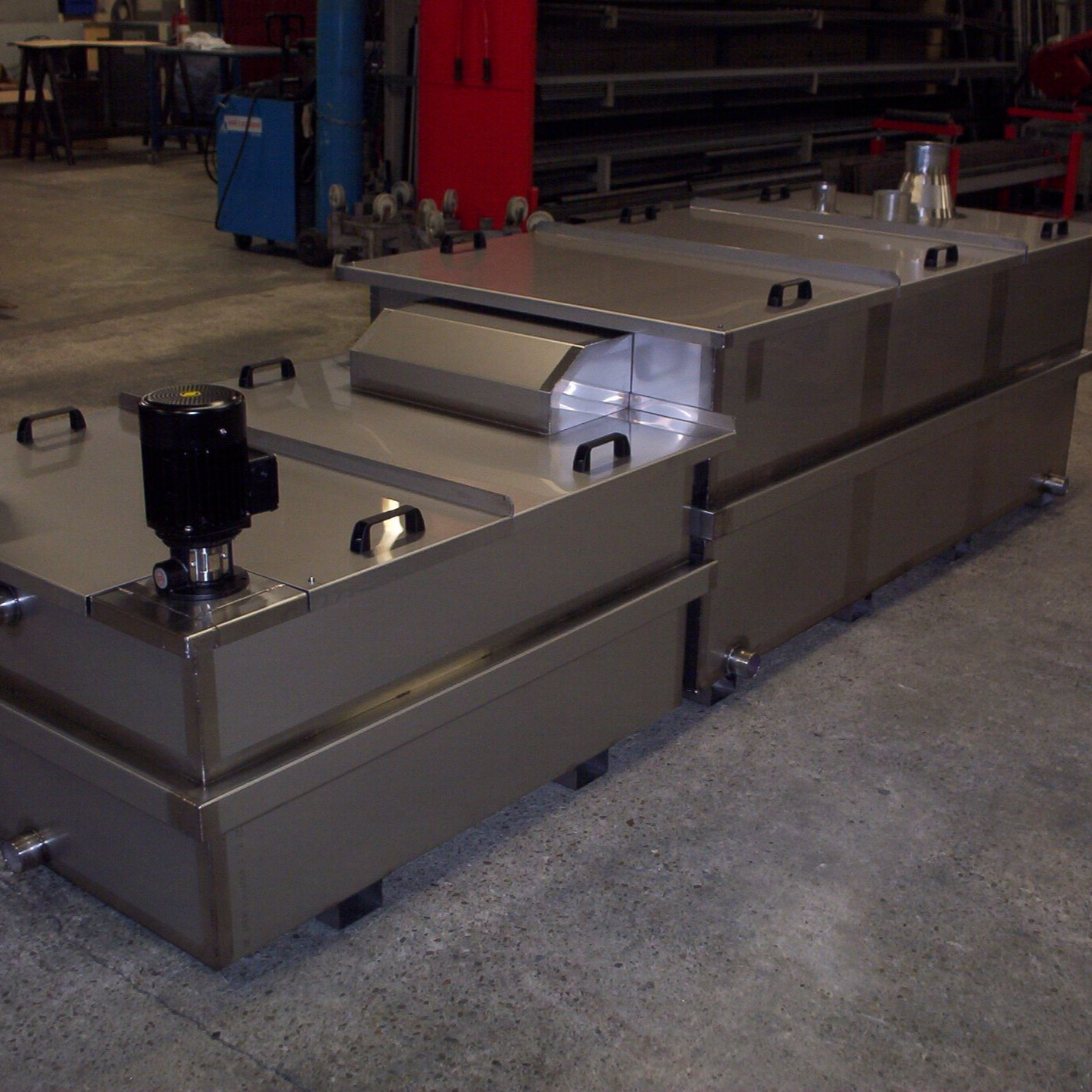 Réservoirs industriels en acier inoxydable dans un atelier.