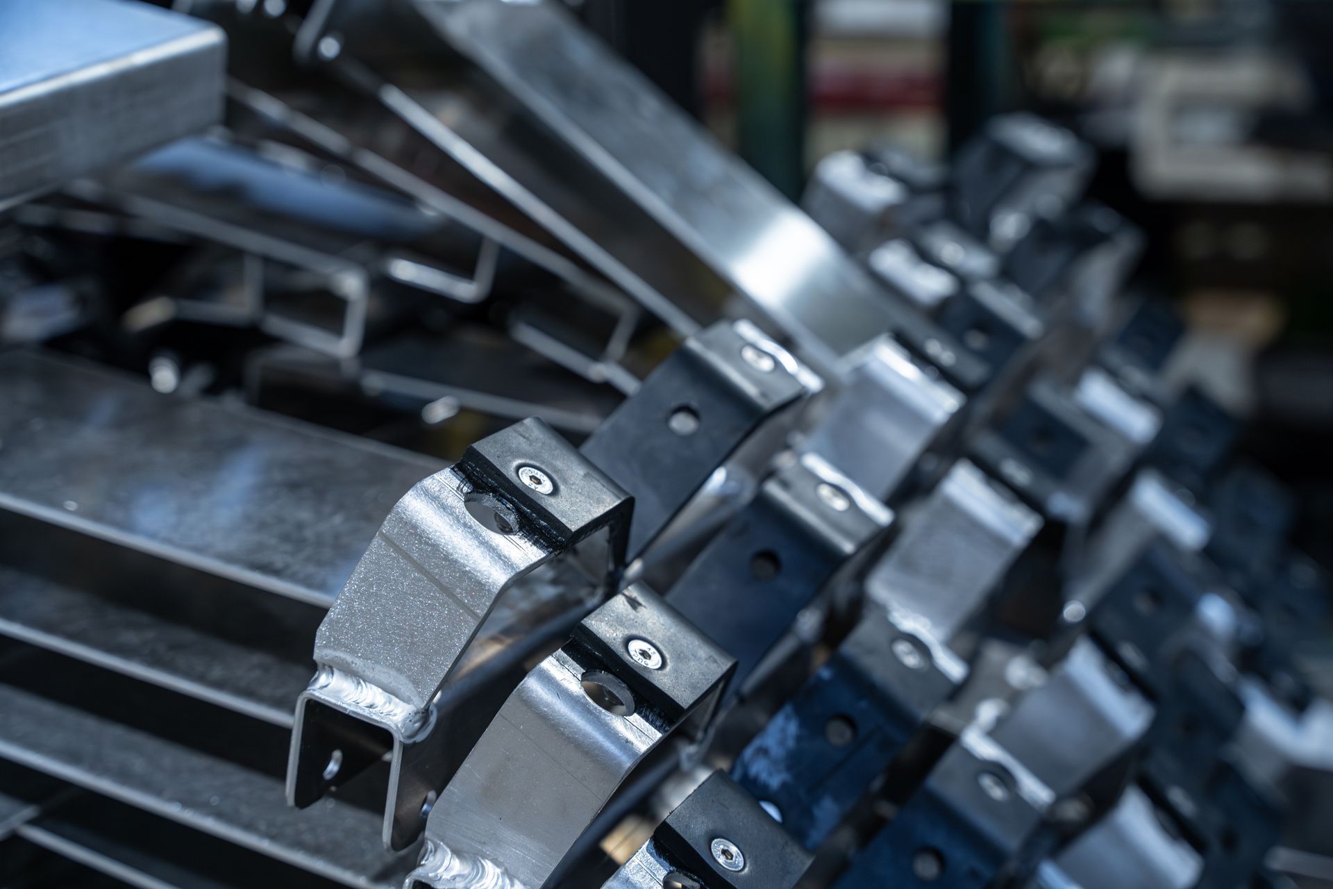 Supports métalliques empilés, avec composants en caoutchouc noir et vis, probablement industriels.