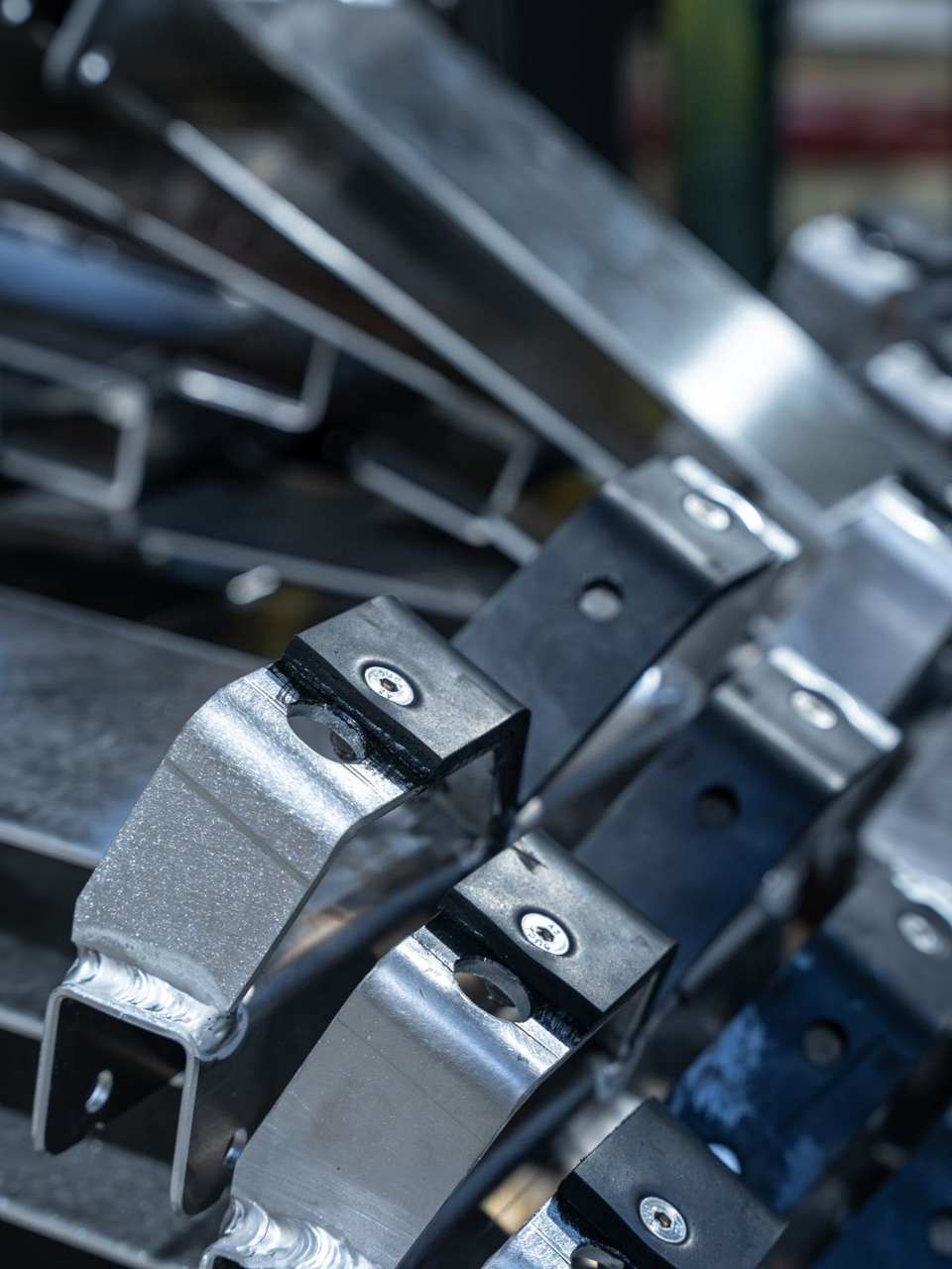 Gros plan sur une pile de supports métalliques avec des coussinets en caoutchouc noir, peut-être des pièces industrielles.