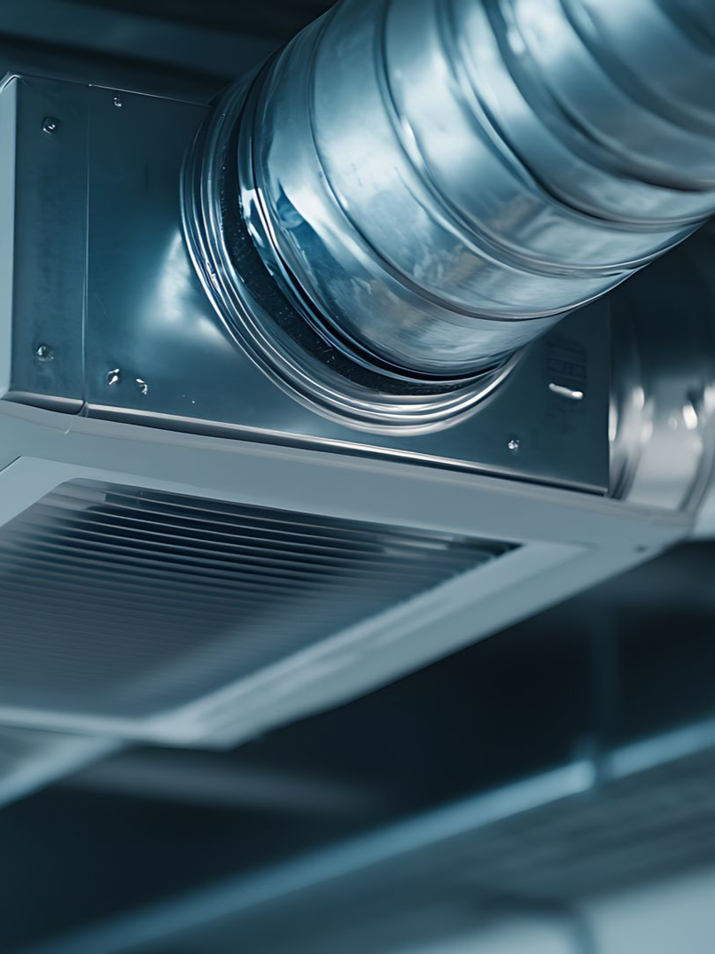 Gros plan sur une bouche d'aération avec un conduit métallique dans un bâtiment.