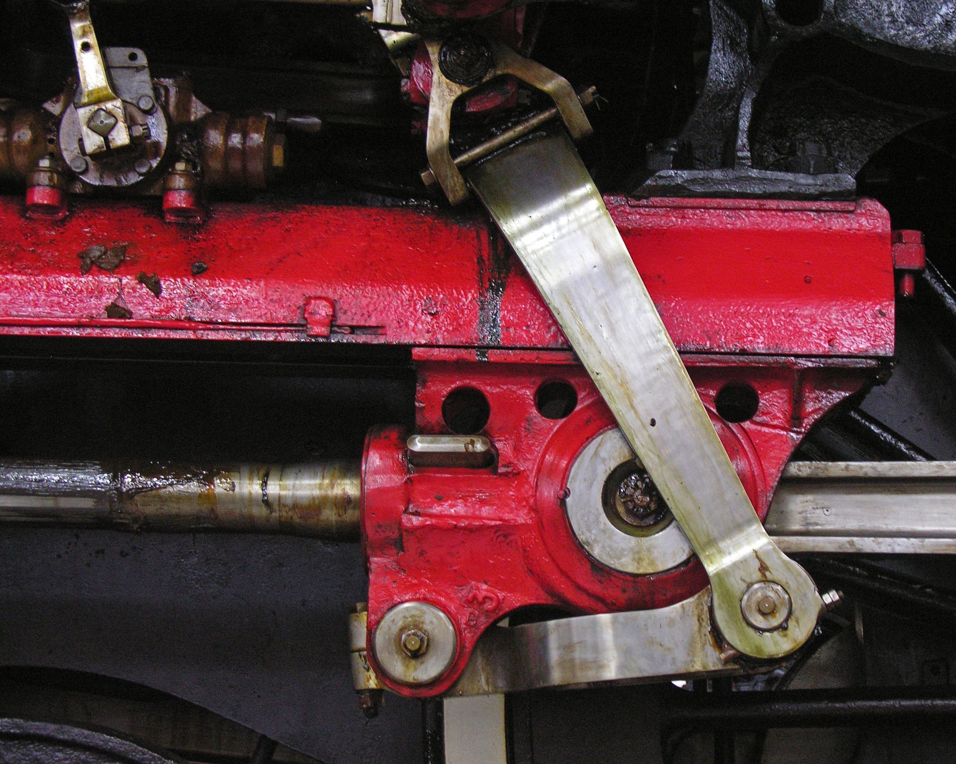 Mécanisme de locomotive peint en rouge avec un levier en métal, une partie du mécanisme d'entraînement, vue rapprochée.