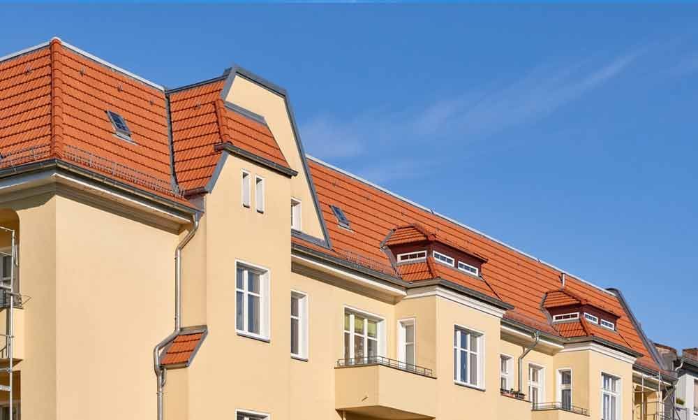 Ein großes gelbes Gebäude mit einem roten Ziegeldach