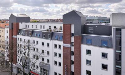 Ein weißes Gebäude mit einem Dach mit vielen Fenstern.