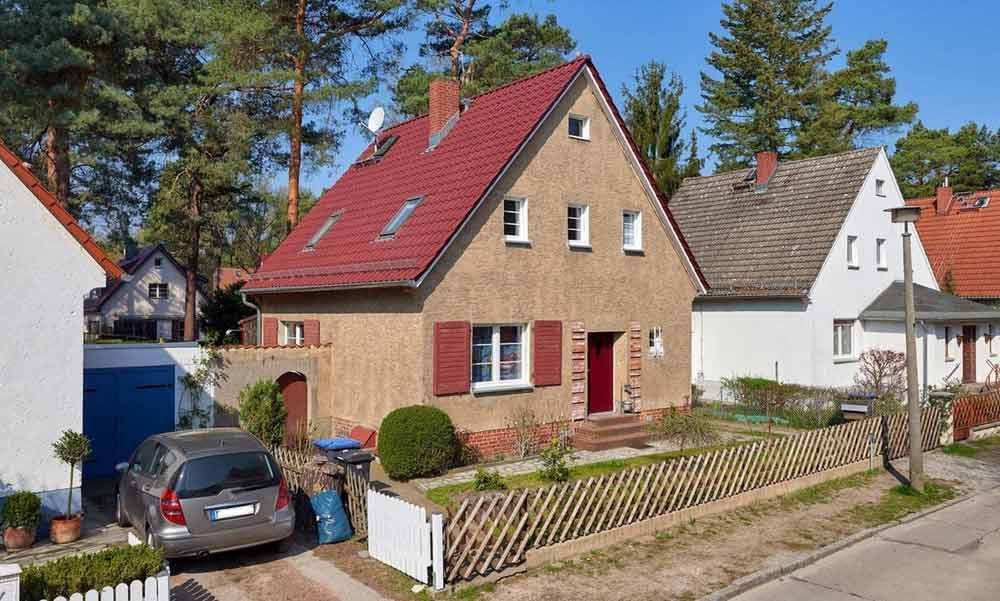 Ein Haus mit einem roten Dach ist von anderen Häusern umgeben