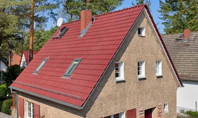 Ein Haus mit einem roten Ziegeldach und zwei Oberlichtern