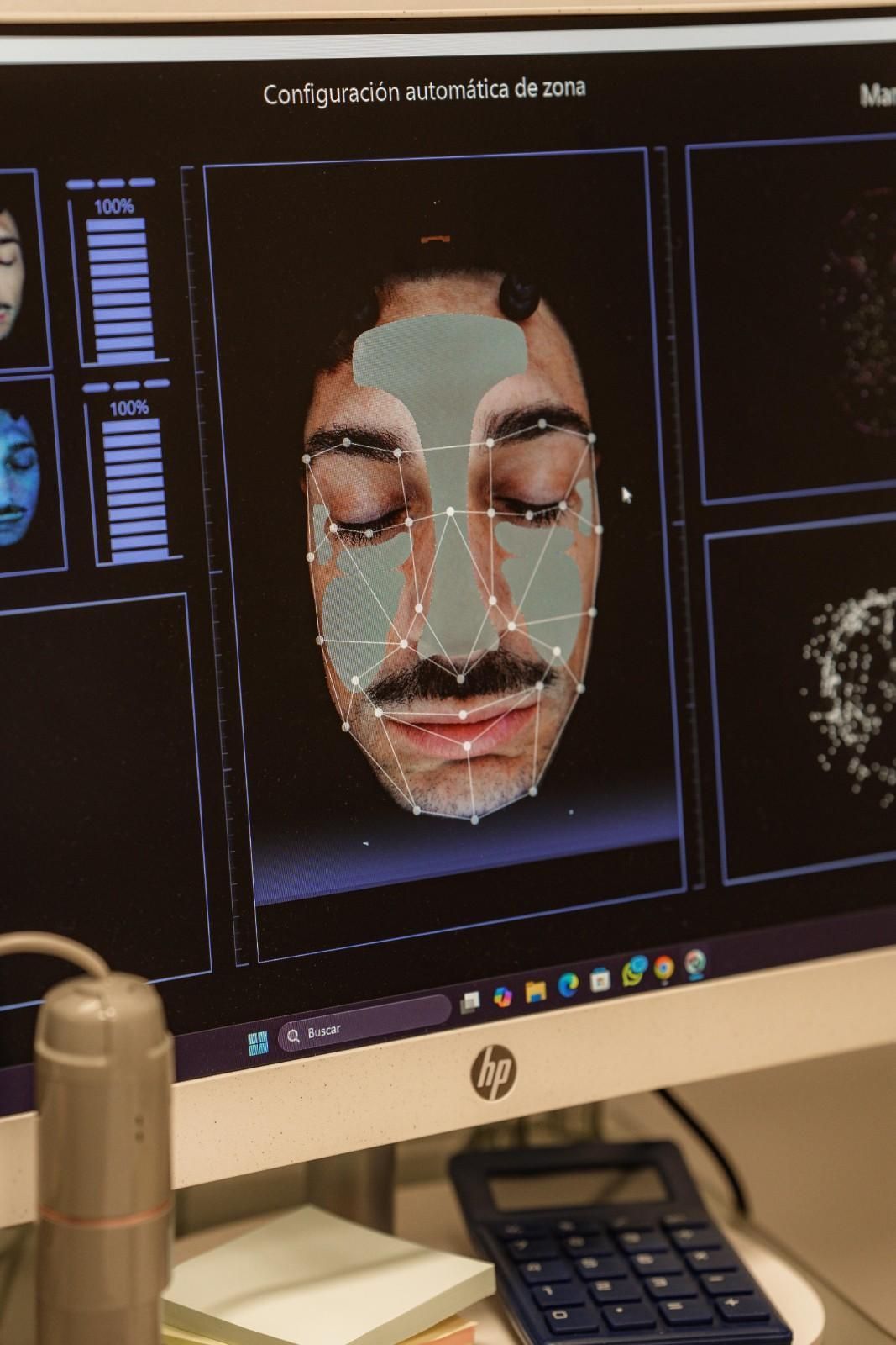 Pantalla de computadora que muestra un análisis facial con una cuadrícula superpuesta. El rostro del hombre está en el centro.
