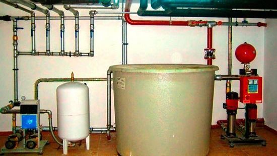 Un tanque grande está rodeado de tuberías en una habitación.