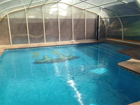 Una gran piscina cubierta con techo transparente.