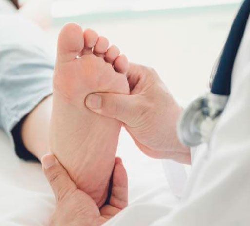 Médico examinando el pie de un paciente durante un chequeo médico.