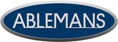 ABLEMANS-logo valkoisella tekstillä sinisellä soikiolla, jossa on hopeinen reunus