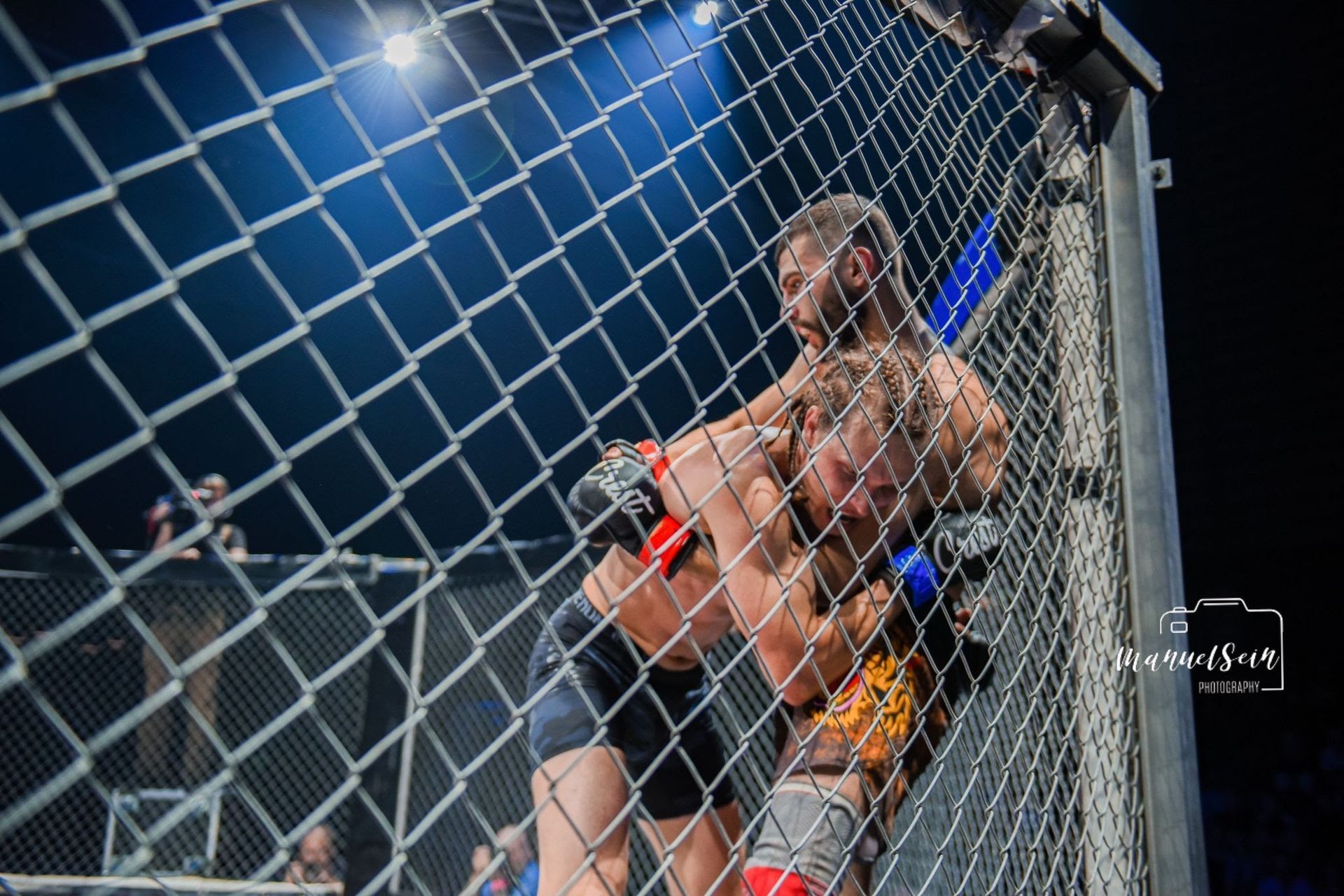 MMA-ottelijat painivat häkkiä vasten kehässä kirkkaiden valojen alla