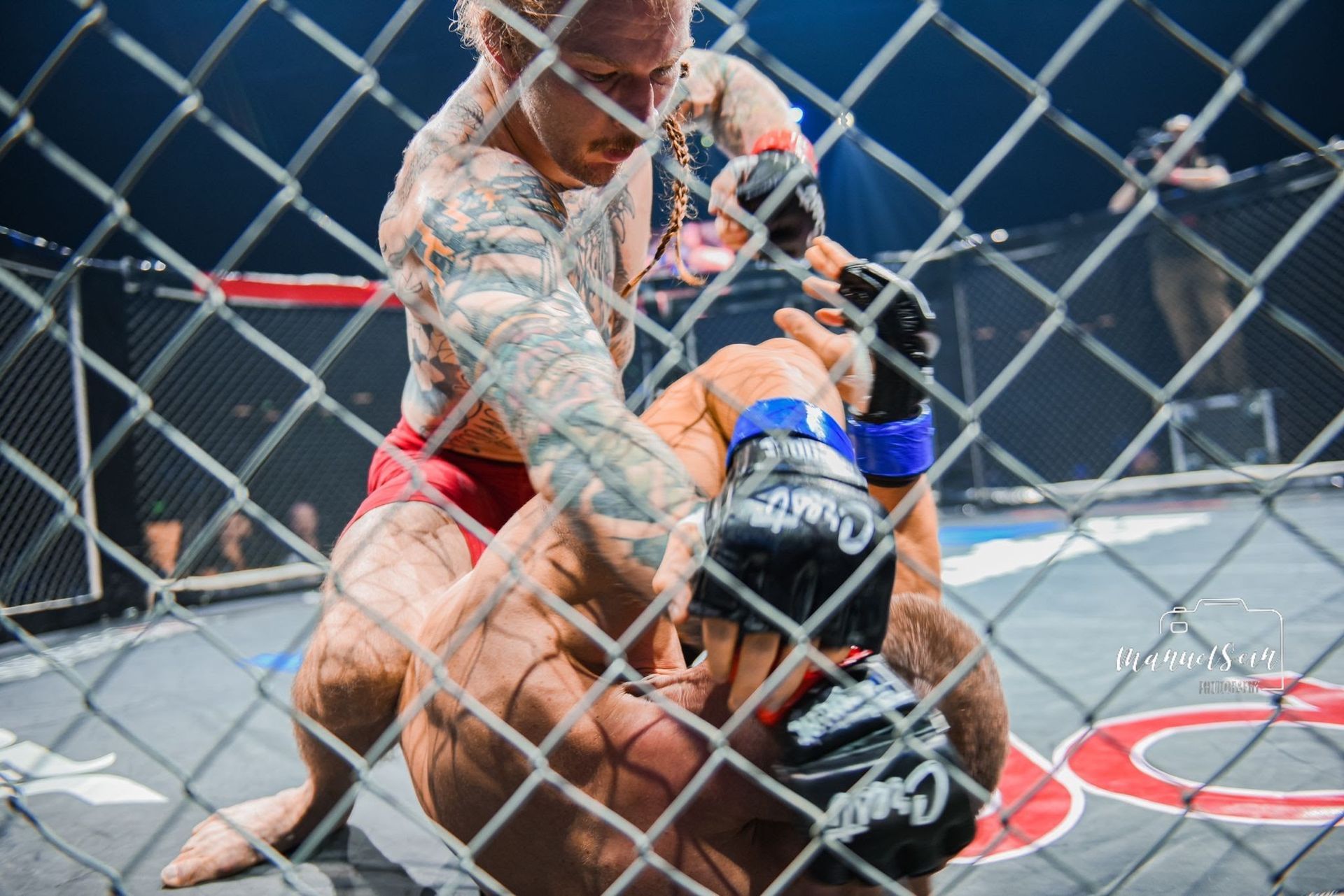 MMA-ottelijat painivat matolla verkkohäkissä ottelun aikana