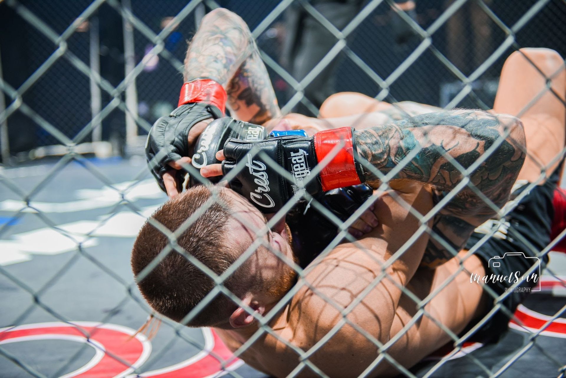 MMA-ottelija matolla peittäytyen verkkoaidan taakse maaottelun aikana