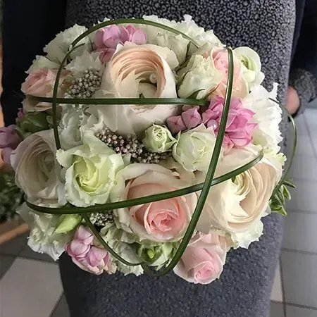 Ein farbenfroher Blumenstrauß mit rosa Gartenrosen, weißen Anemonen, lila Flieder und kleinen blauen Blüten.