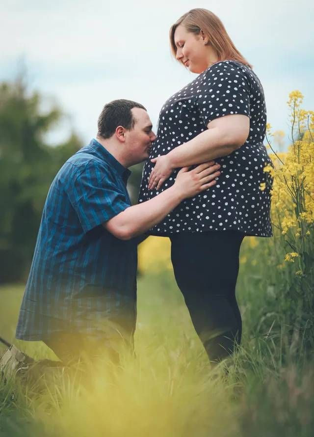 Babybauchshooting - ein Mann küsst den Bauch seiner schwangeren Frau bei Mockibby Fotografie