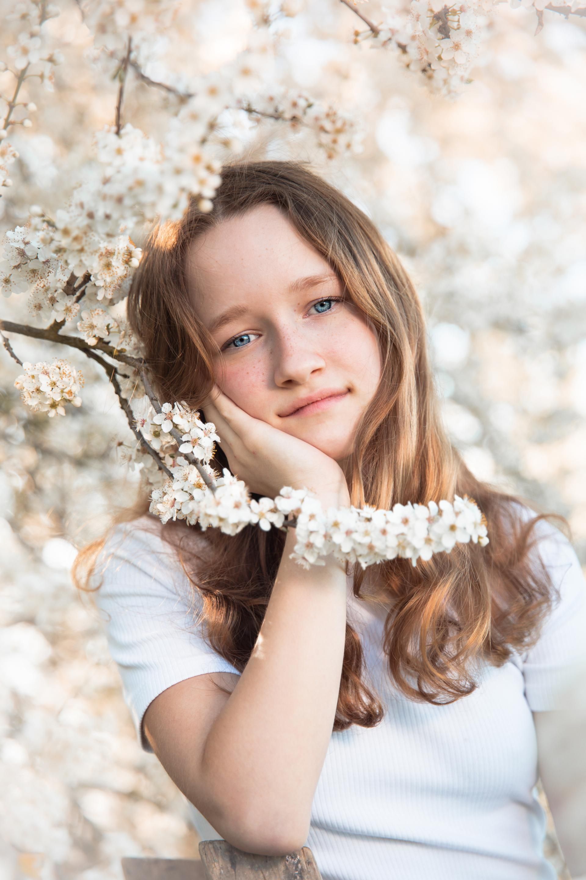 Kinderfotografie – Mädchen zwischen blühenden Ästen
