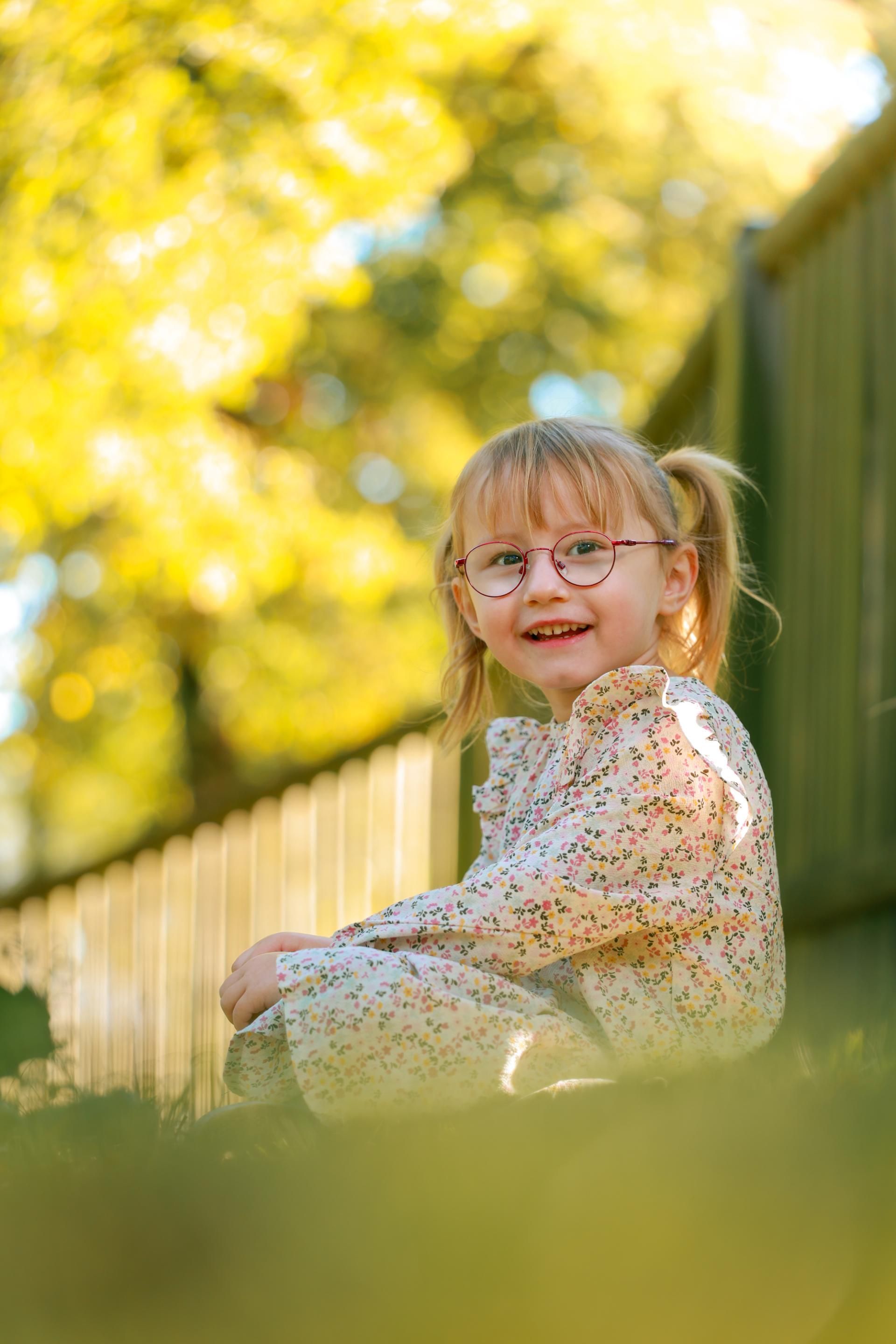 Kinderfotografie – Kind spielt lachend auf einer Wiese