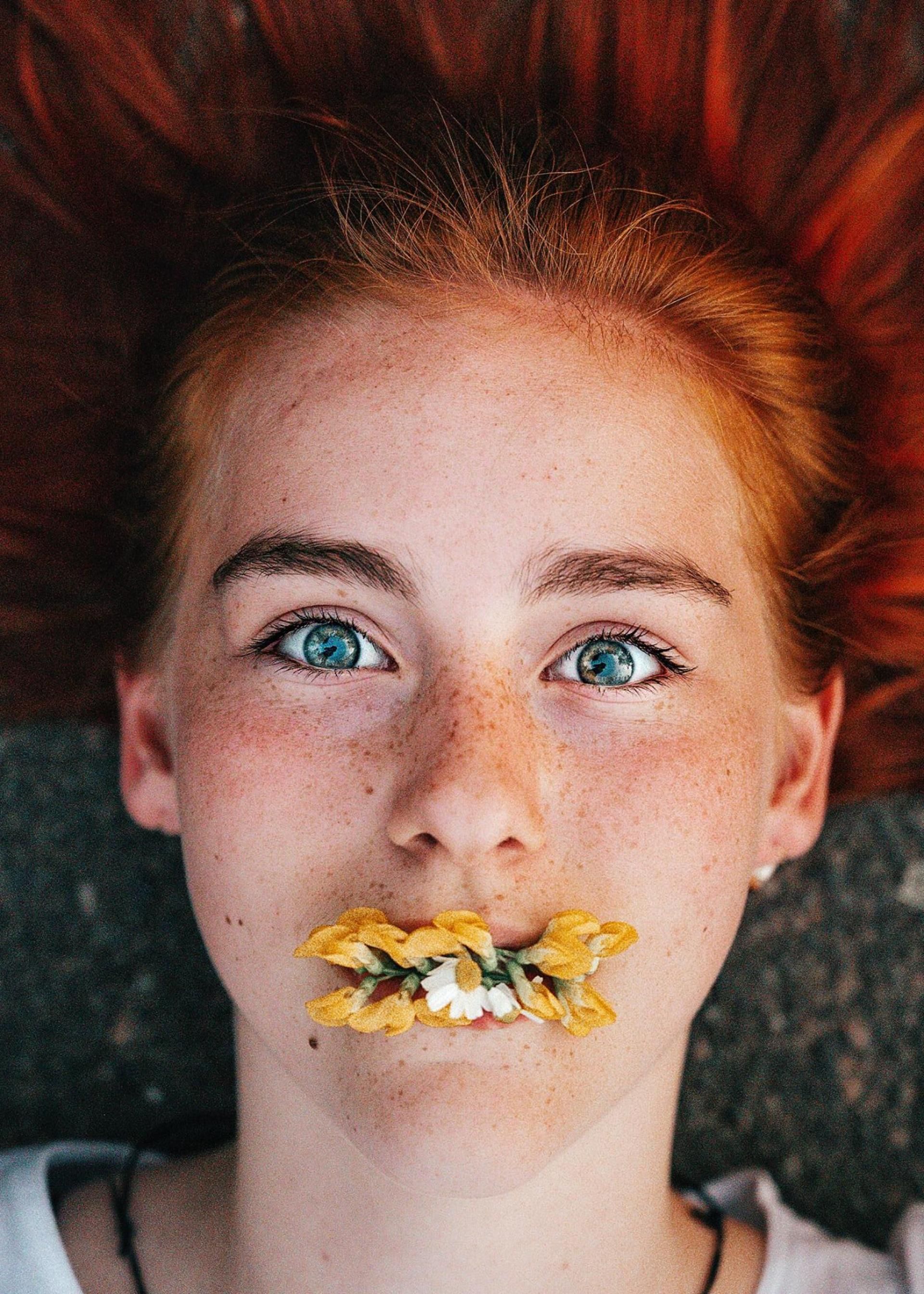 Portraitbilder - Ein Mädchen mit Blume in den Mund bei Mockibby Fotografie