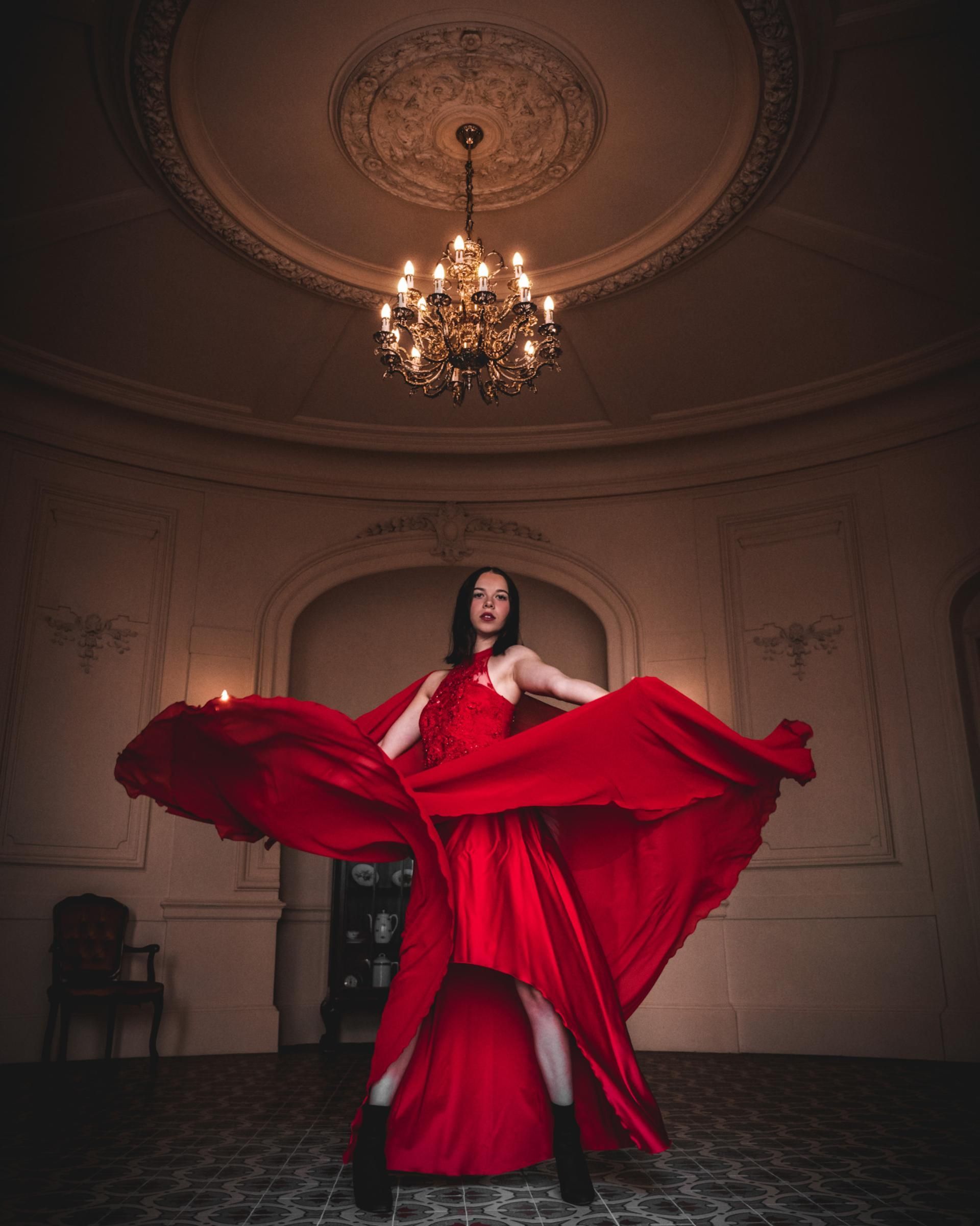 Porträtfotografie – Frau im roten Kleid tanzt im Ballsaal