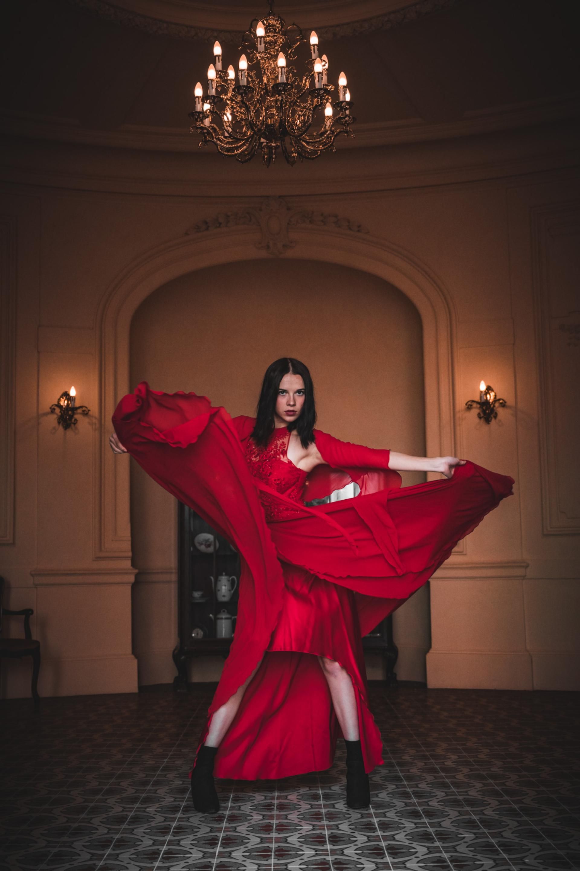 Porträtfotografie – Tanz mit rotem Kleid unter Kronleuchter