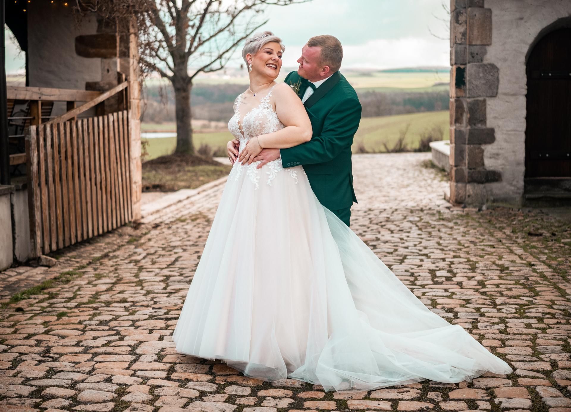 Hochzeitsfotografie – Brautpaar tanzt auf einem gepflasterten Weg