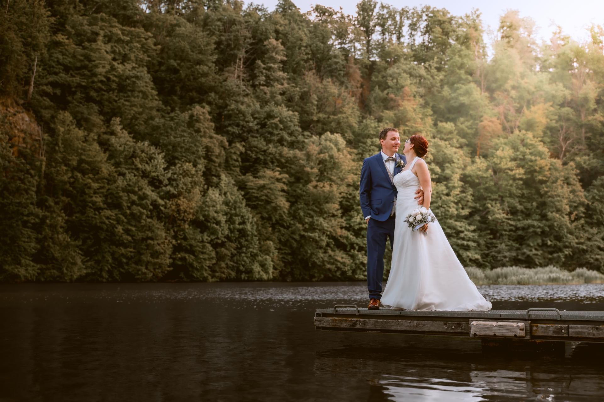 Hochzeitsfotografie – Brautpaar steht auf einem Steg am See