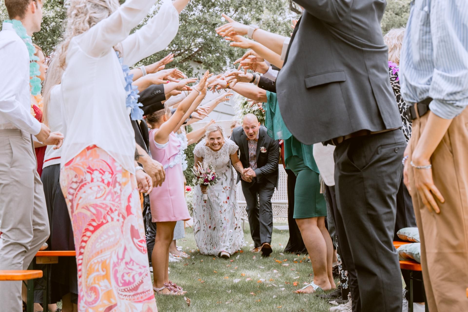 Hochzeitsfotografie – Brautpaar läuft durch Spalier von Gästen