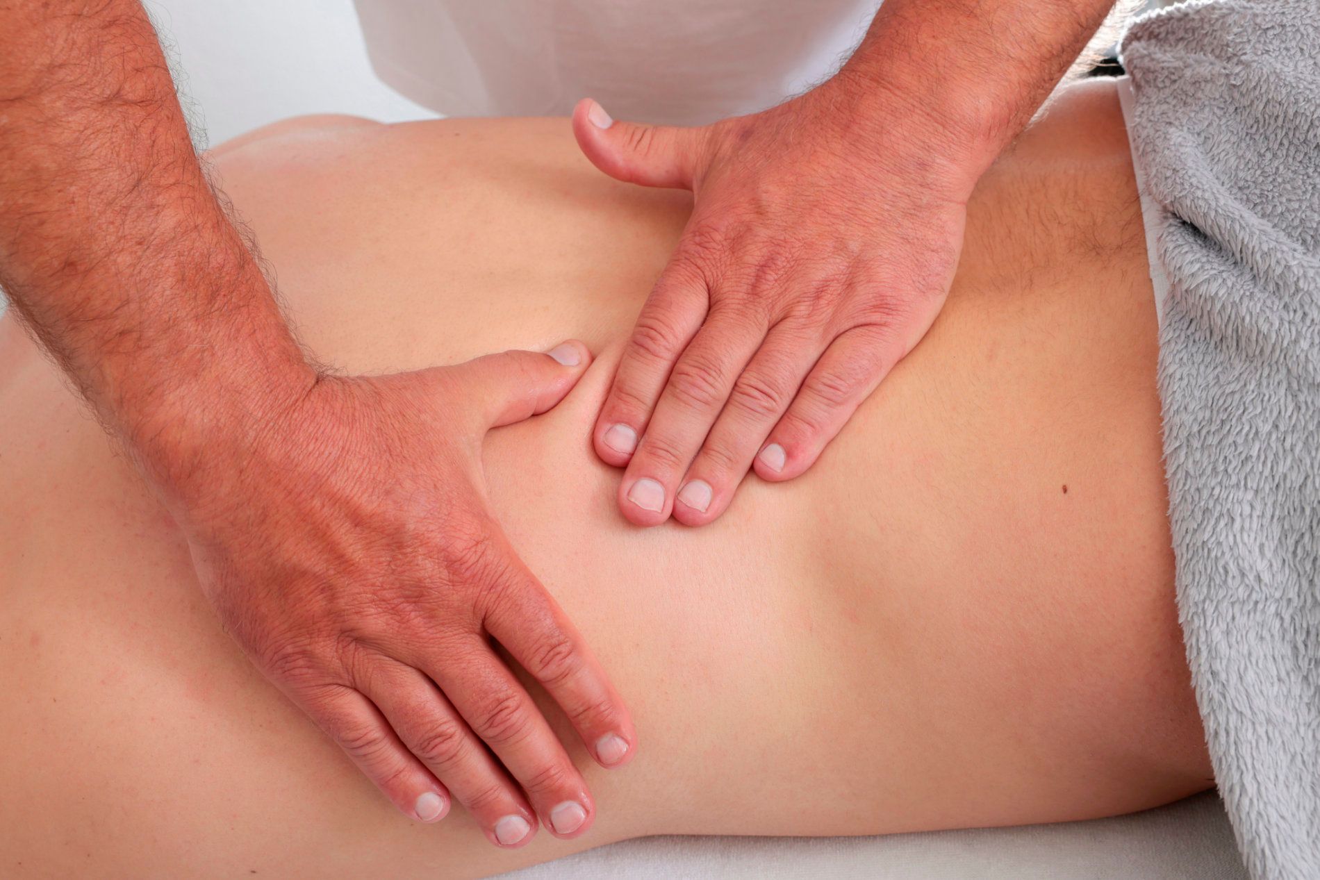 Ein Mann massiert einer Frau den Rücken.