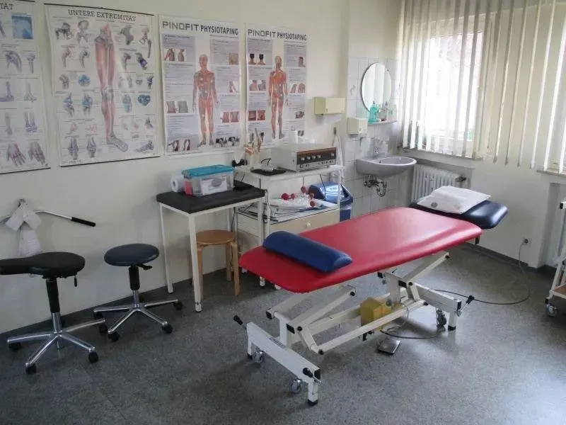 Ein Physiotherapieraum mit einem roten Tisch