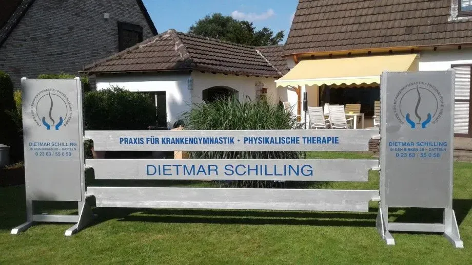 Vor einem Haus steht ein Zaun