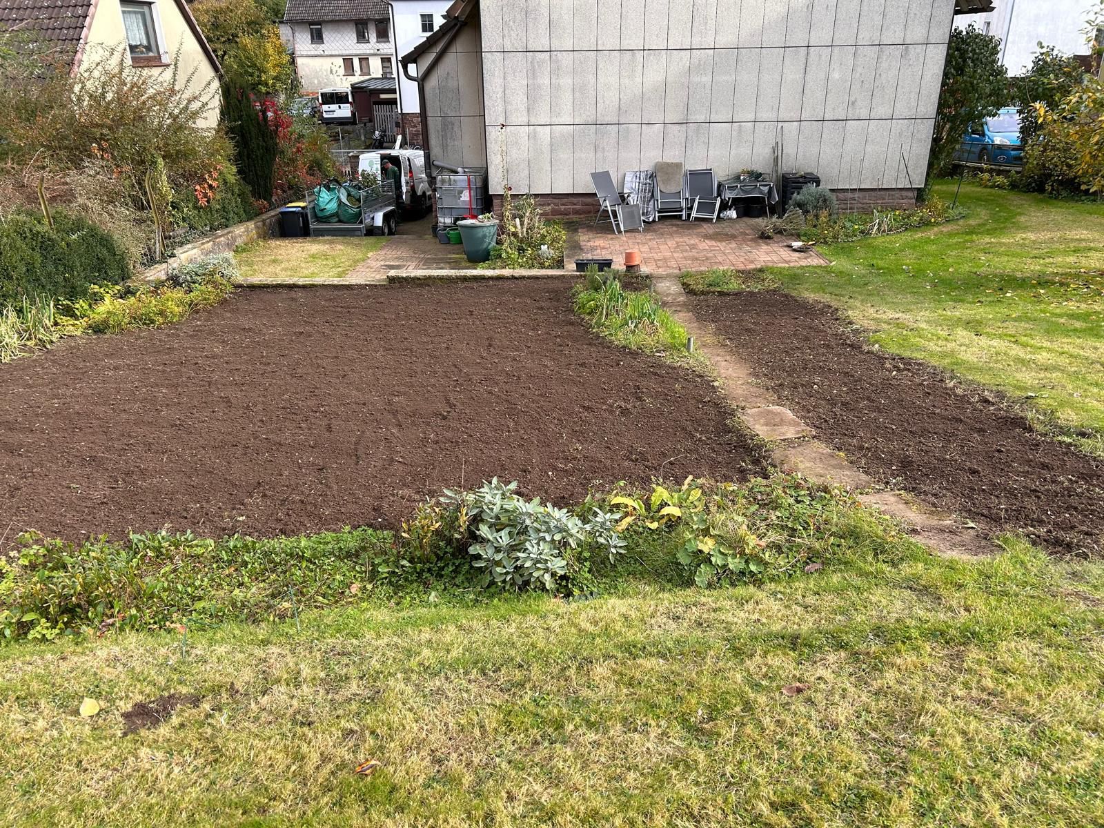 Eine große Wiese vor einem Haus mit viel Dreck darin.
