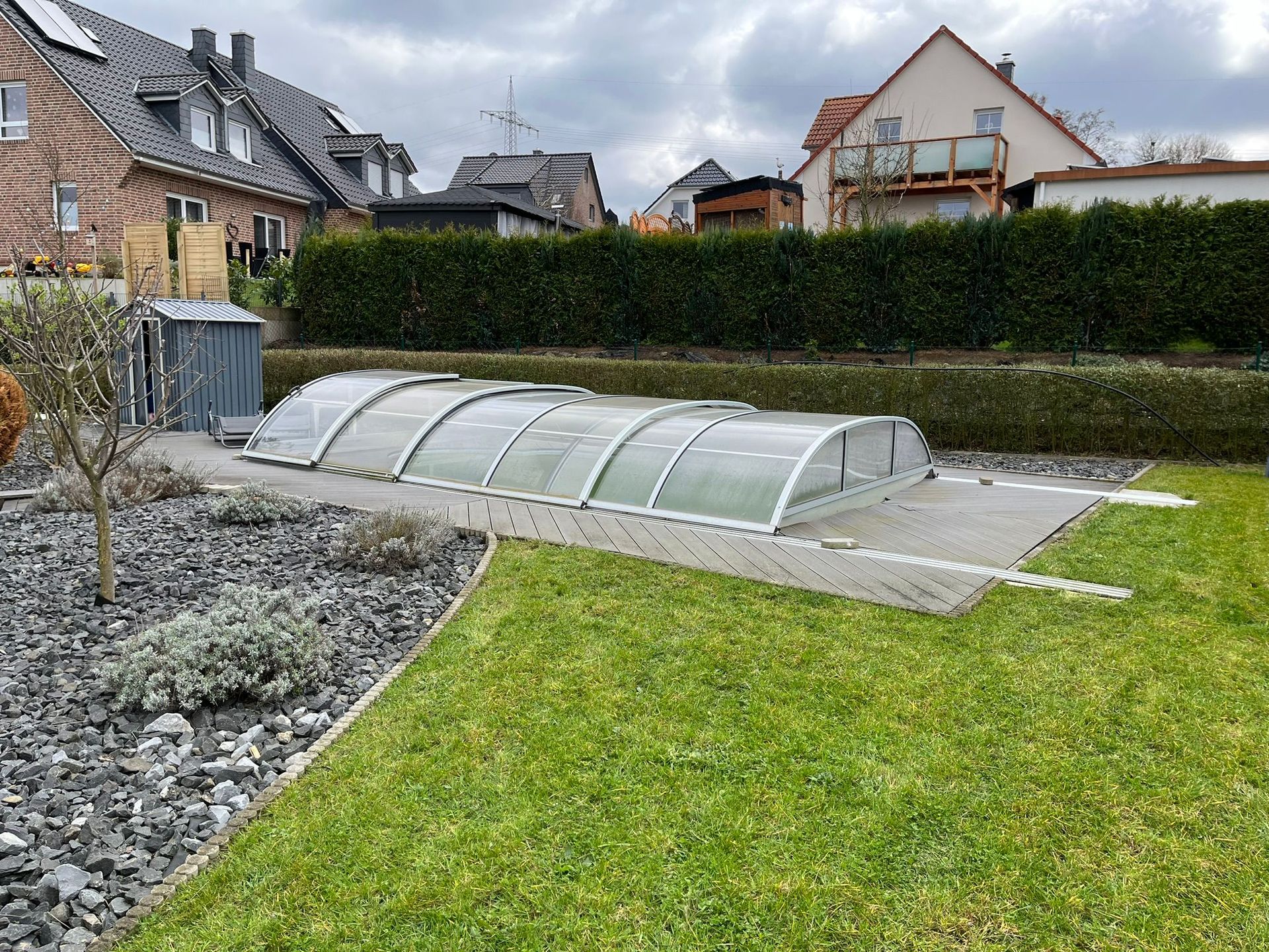 Ein Swimmingpool mit Abdeckung im Hinterhof eines Hauses.