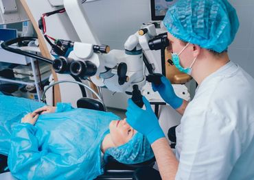 Un cirujano está usando un microscopio para observar el ojo de un paciente.