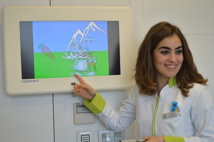 Una mujer con una bata de laboratorio señala una pantalla con una caricatura.