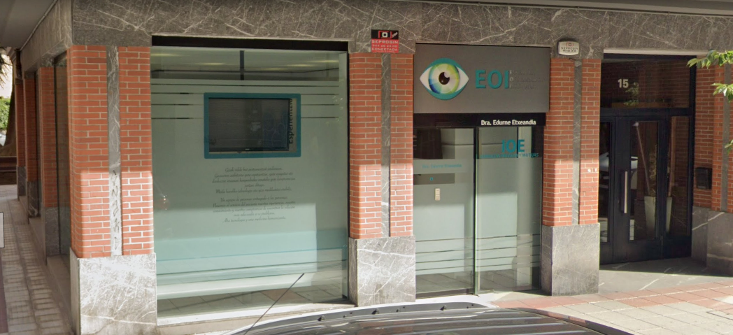 Un edificio de ladrillo con una puerta de vidrio y un televisor en la pared.