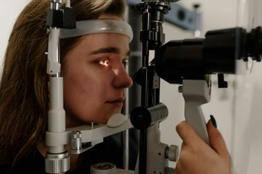Una mujer está siendo examinada por un oftalmólogo.