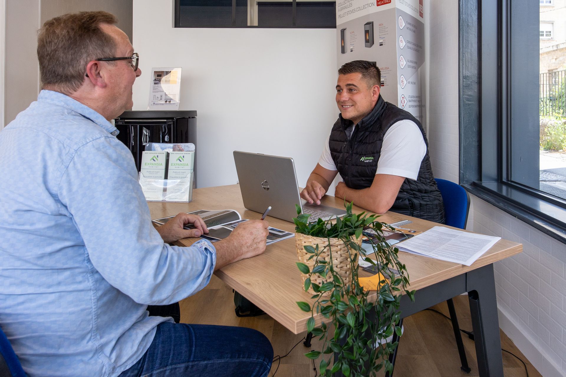 Un homme derrière un ordinateur discute avec un homme