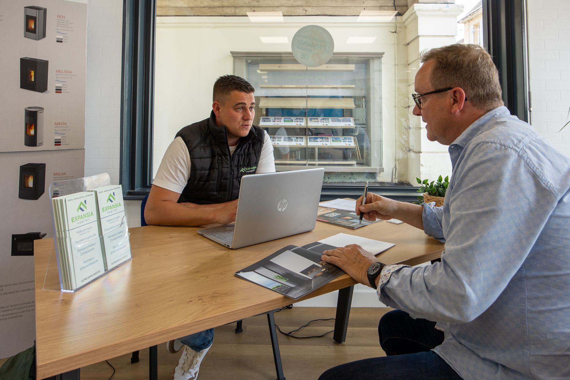 Deux hommes discutent assis à un bureau