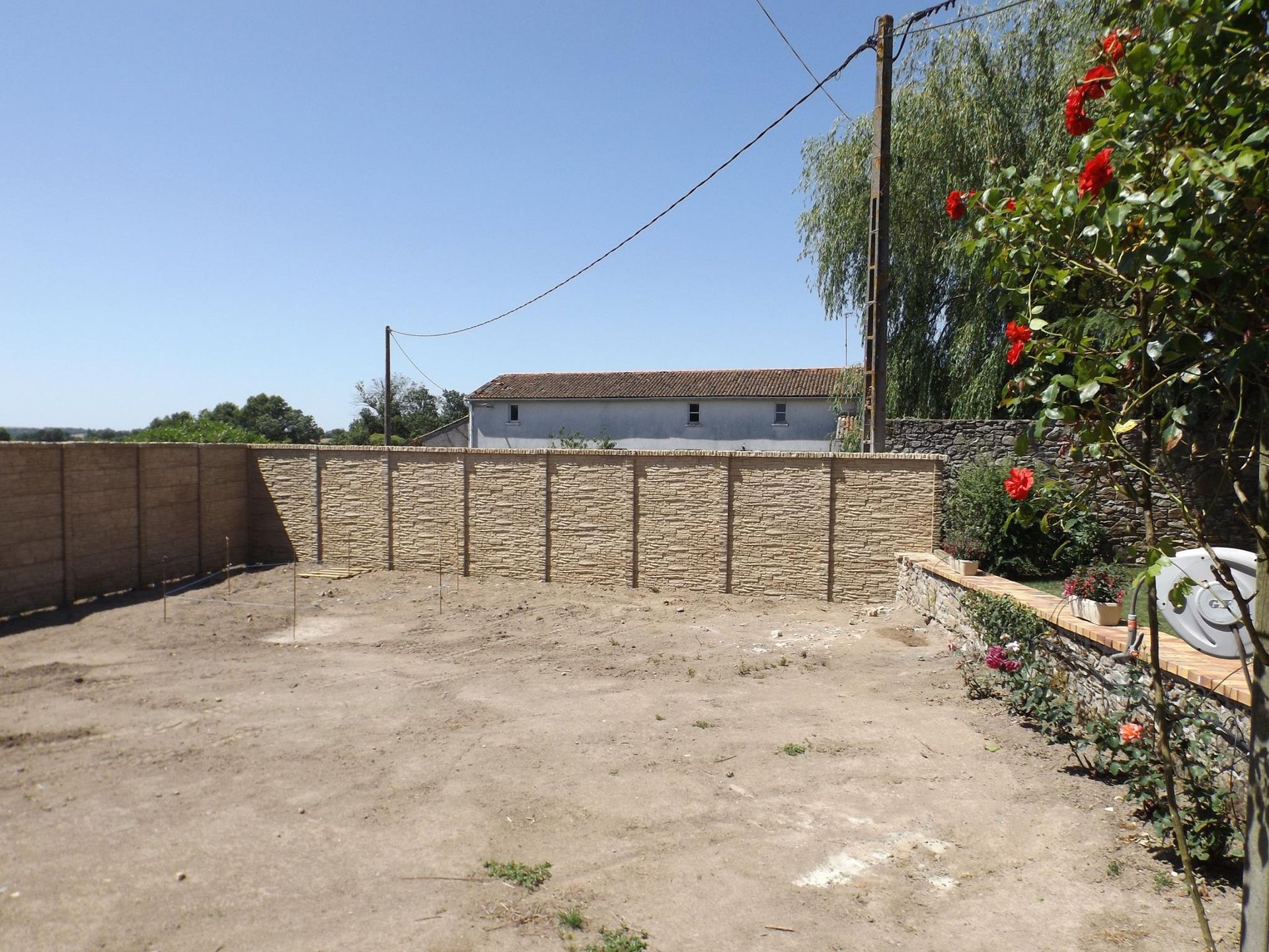 Terrassement de terrain devant un muret en pierre