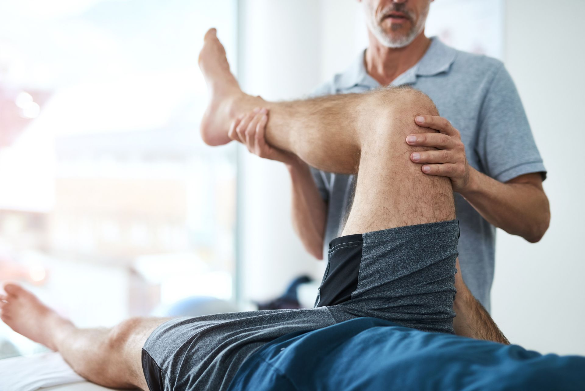 Un hombre está recibiendo un masaje en las piernas por parte de un médico.