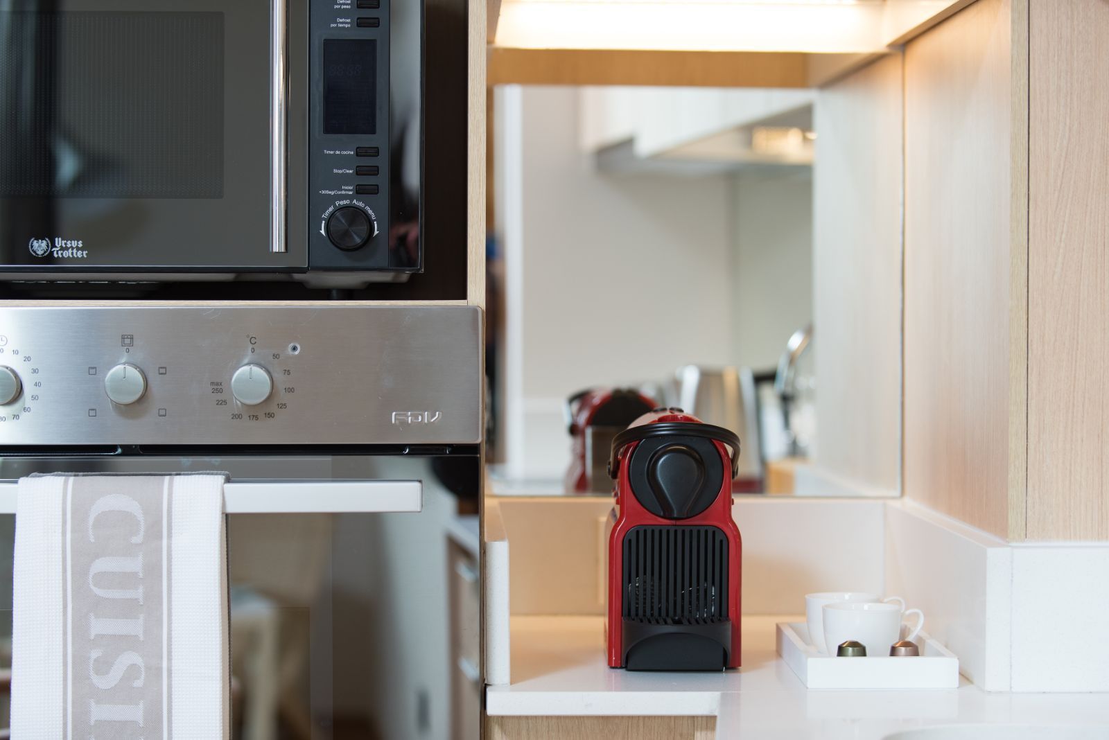 Red-and-black camera on a shelf beside a microwave in a bright kitchen nook