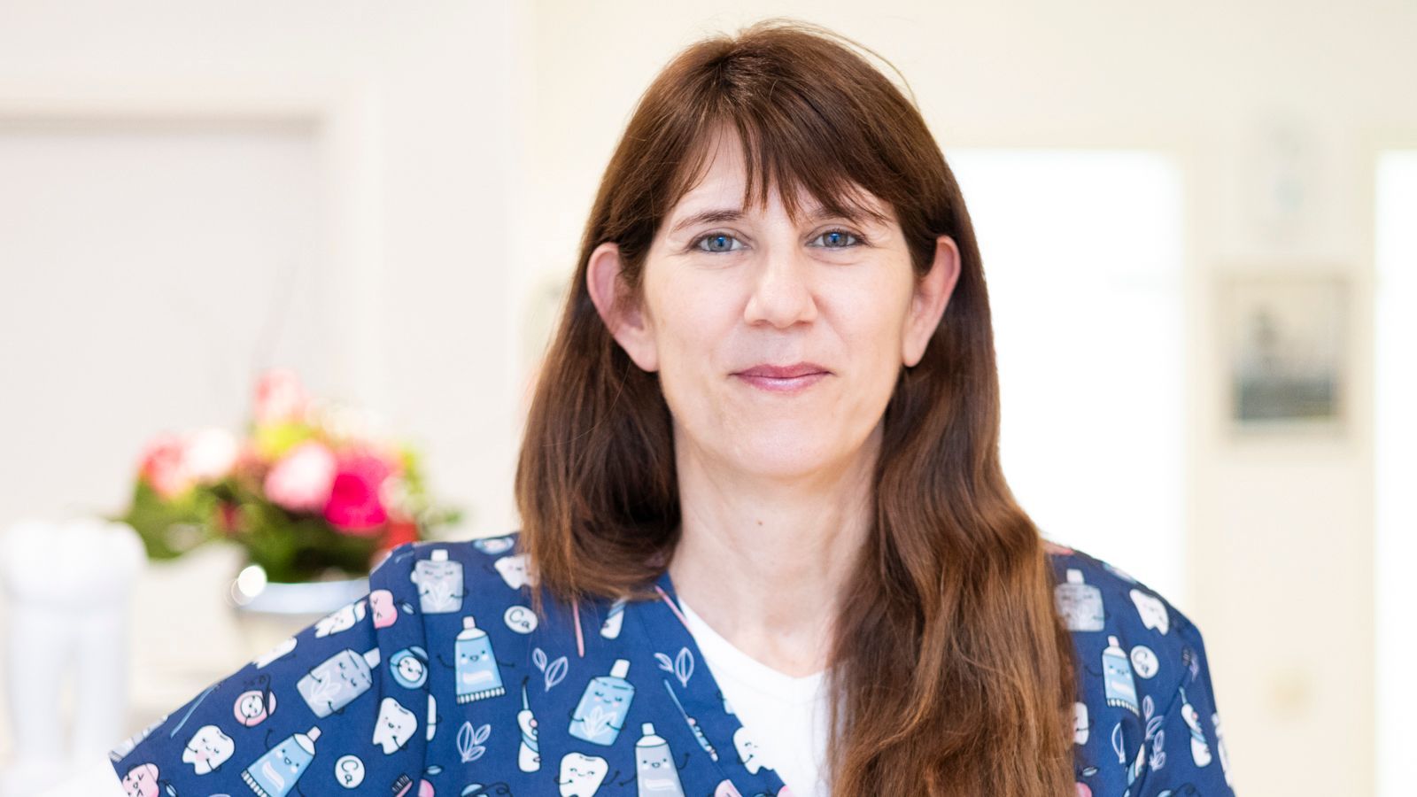 Eine Frau im blauen OP-Kittel schaut in die Kamera.