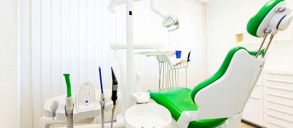 Ein grün-weißer Zahnarztstuhl in einer Zahnarztpraxis.