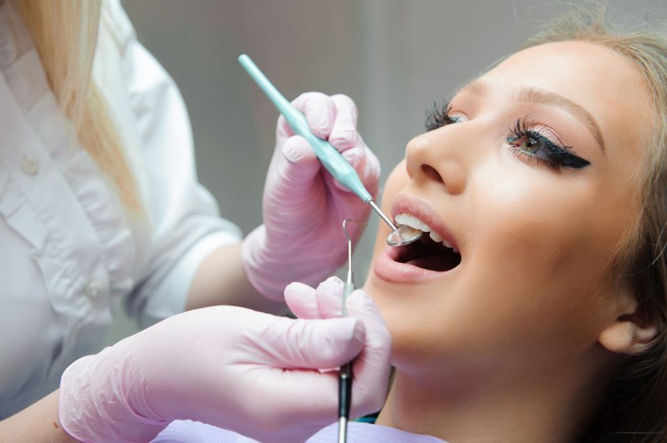 Eine Frau lässt ihre Zähne von einem Zahnarzt untersuchen.