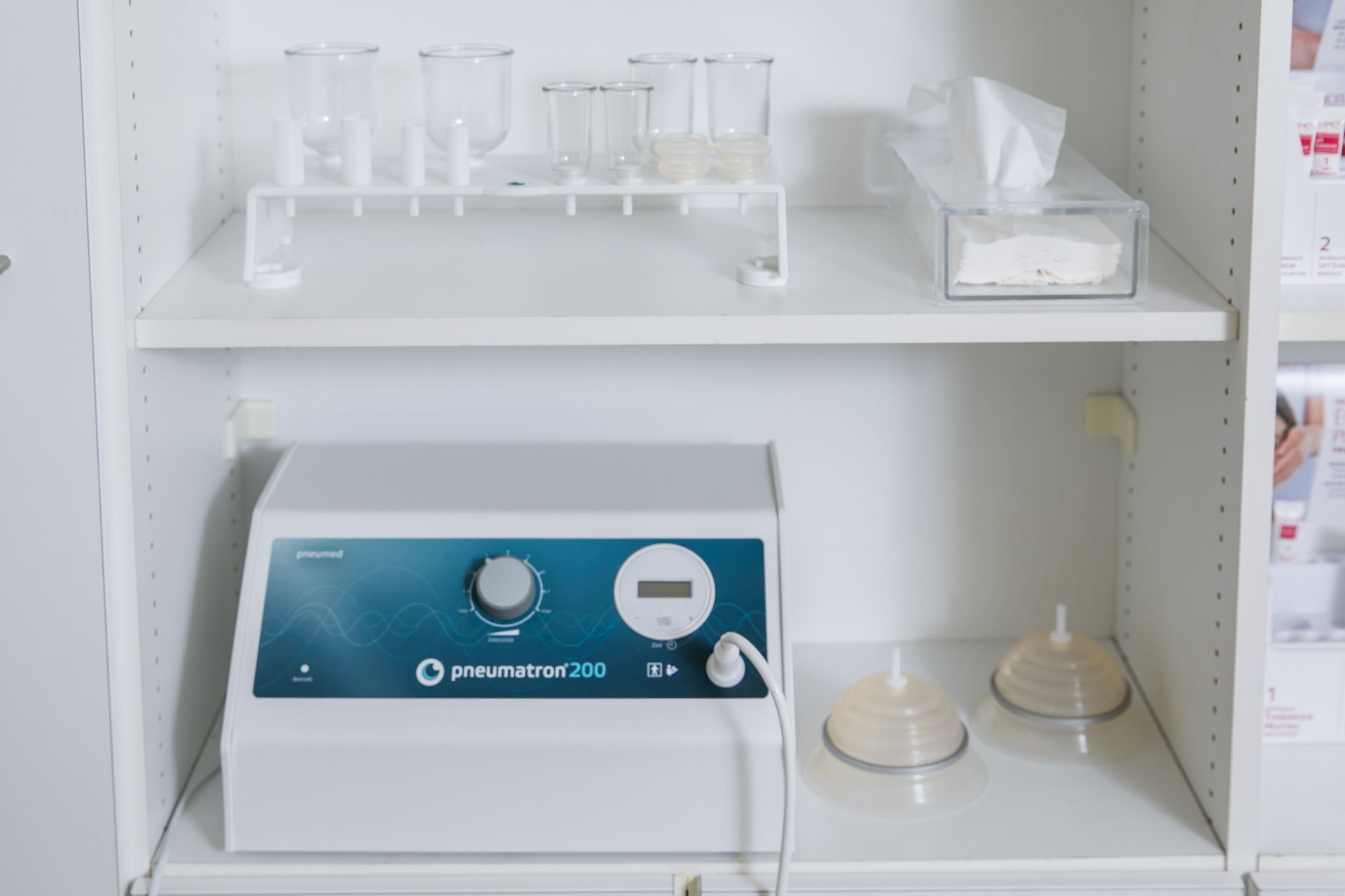 Medizinisches Gerät mit Bechern und Fläschchen auf einem Regal.