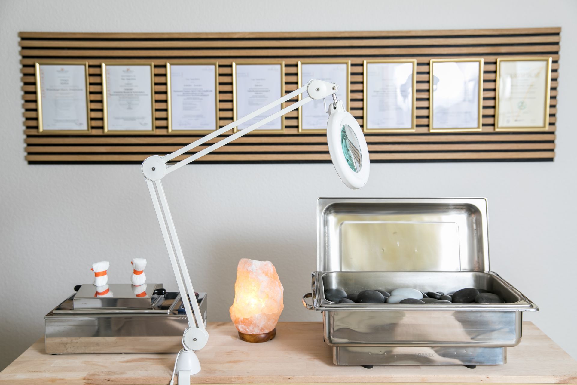 Spa-Setup: Hot-Stone-Wärmer, Lupenlampe, Salzlampe, gerahmte Dokumente.