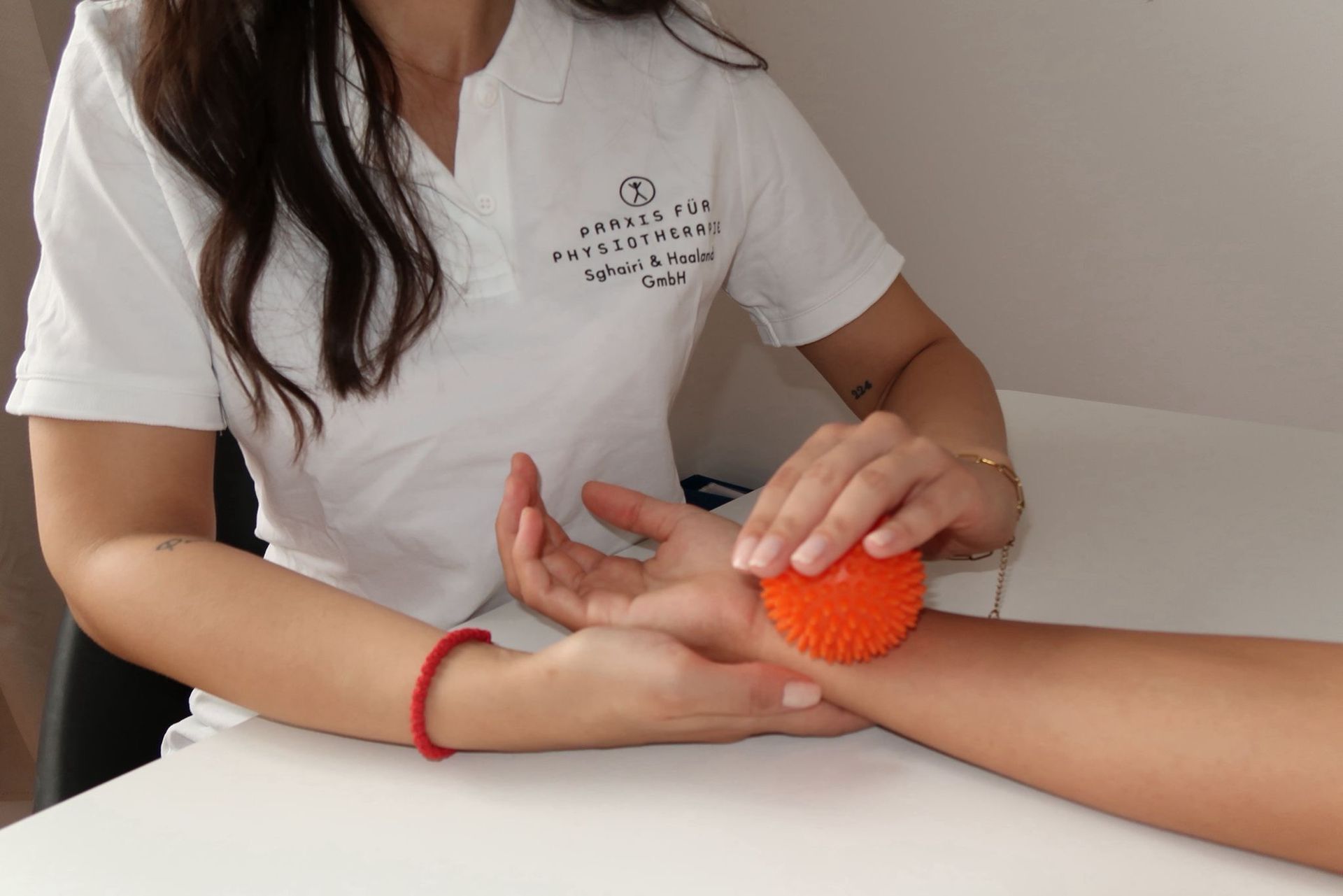 Hände, die während einer Erste-Hilfe-Behandlung einen weißen Verband um ein Handgelenk wickeln