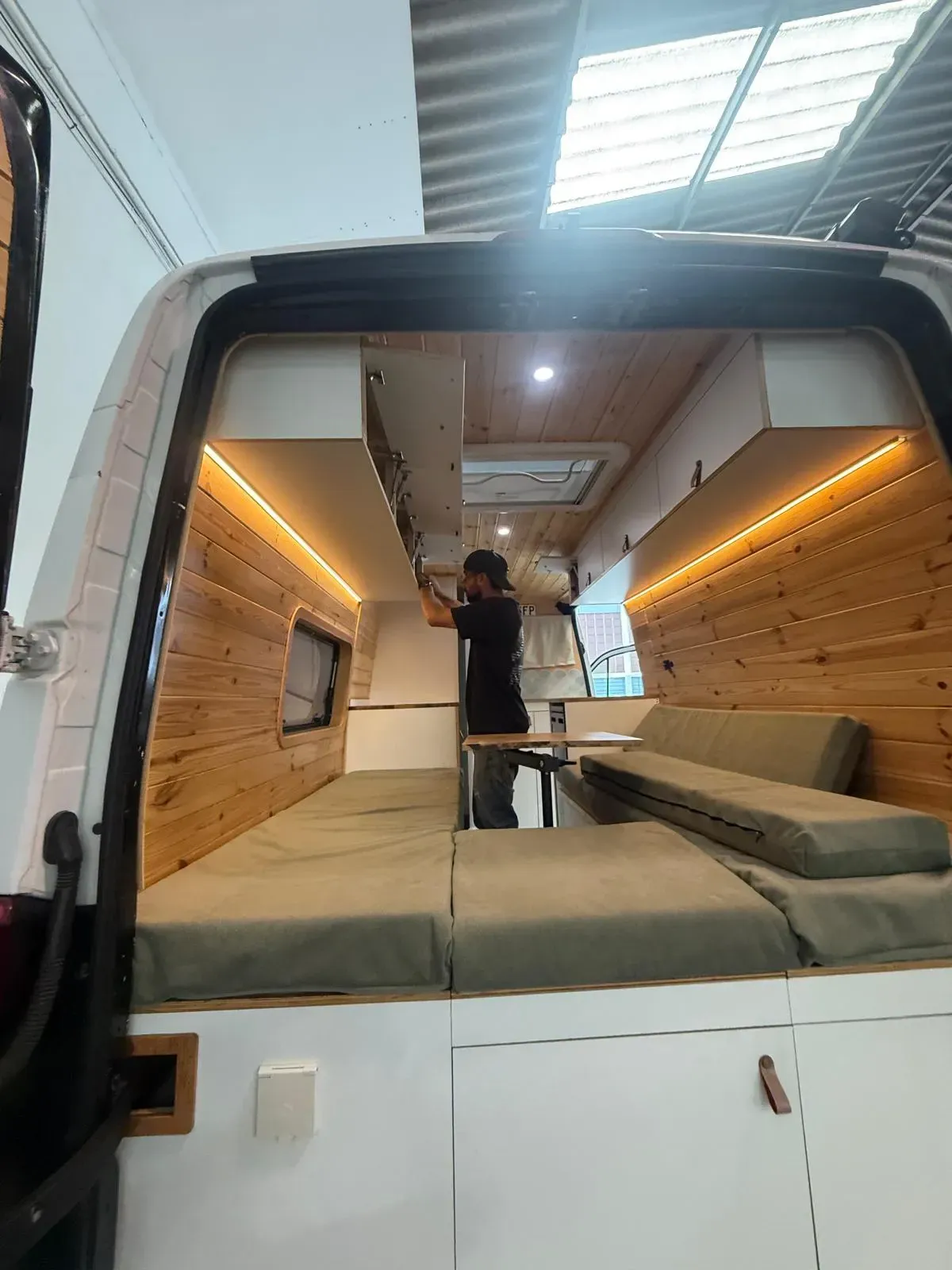Interior de una furgoneta camperizada con paneles de madera